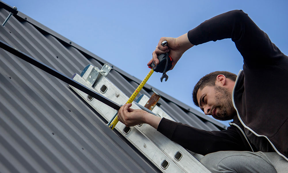 Measuring the roof pitch using a level and tape measure